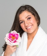 spa woman in robe holding beautiful flower